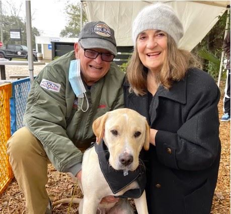 two people holding a dog